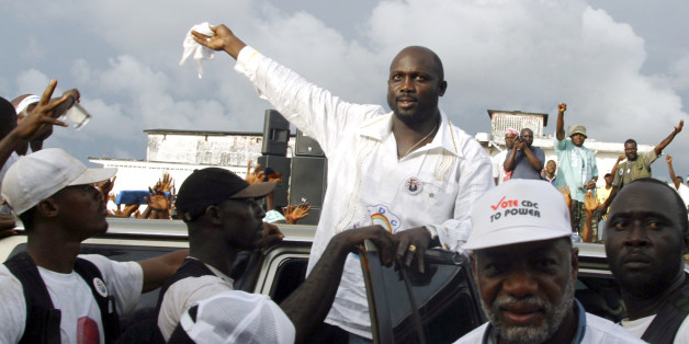 Liberian presidential candidate and former world footballer of the year George Weah (C) arrives for an address to supporters in Monrovia November 6, 2005. Weah will face a presidential run-off on Tuesday against Ellen Johnson-Sirleaf, a former finance minister known as the "Iron Lady". Liberians hope a second-round presidential run-off can heal the wounds left by a brutal civil war. Picture taken November 6, 2005. REUTERS/Tim Hetherington