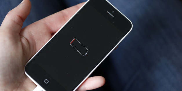 PARIS, FRANCE - DECEMBER 23: In this photo illustration a woman holds an Apple mobile phone iPhone 5 on the screen of which we can see the battery charge indicator on December 23, 2017 in Paris, France. Apple has admitted that it was clamping the processors of old iPhone at certain stages of their life cycles, to deliberately slow down the performance of batteries of older models of iPhone. (Photo by Chesnot/Getty Images)