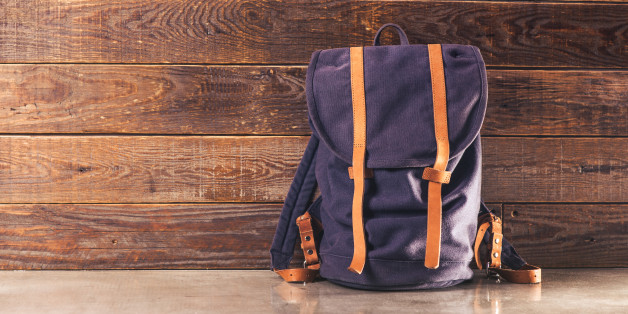 Canvas and leather backpack on wooden wall