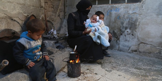DAMASCUS, SYRIA - DECEMBER 28: A woman holds Syrian baby Karim, who lost his left eye and his mother after Assad regime's attack on Hammuriye district, in besieged Damascus suburb of Eastern Ghouta, Syria on December 28, 2017. Baby Karim is at risk of losing his right eye as well. (Photo by Amer Alshami/Anadolu Agency/Getty Images)