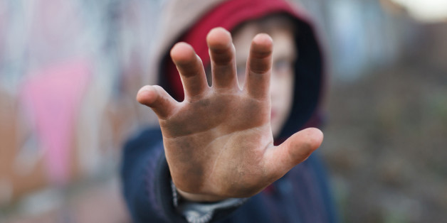 dramatic portrait of a little homeless boy, dirty hand, poverty, city, street
