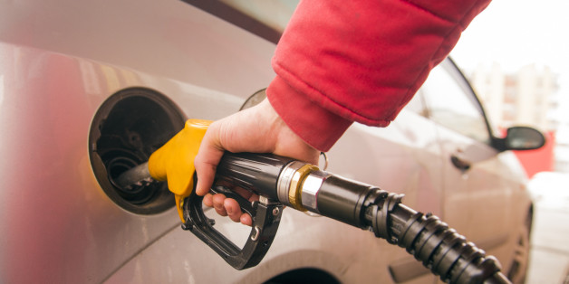 Car refueling on petrol station. Man pumping gasoline oil during the day