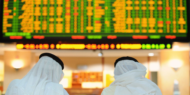Investors look up at electronic boards displaying stock information at the ADX Abu Dhabi Securities Exchange stock market May 16, 2012. REUTERS/Ben Job (UNITED ARAB EMIRATES - Tags: BUSINESS)