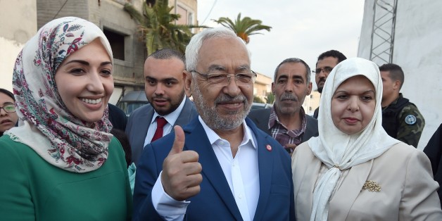 Tunisian Islamist Ennahda Party leader and founder, Rached Ghannouchi (C) poses with his wife (R) and daugther Soumaya (L) as they arrive to vote in the country's first post-revolution parliamentary election at Kairouan primary school turned into a polling station on October 26, 2014 in the Tunis suburb of Ben Arous. Tunisians were voting in an election seen as pivotal to establishing democracy in the cradle of the Arab Spring uprisings, with security forces deploying heavily to avert extremist