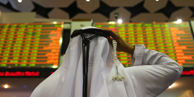 A visitor holds prayer beads while looking at financial information screens at the Dubai Financial Market (DFM) in Dubai, United Arab Emirates, on Tuesday, Nov. 10, 2015. Dubai's index declined for three straight months after a collapse in the price of crude battered economies in the oil-producing nations of the Gulf Cooperation Council. Photographer: Jasper Juinen/Bloomberg via Getty Images