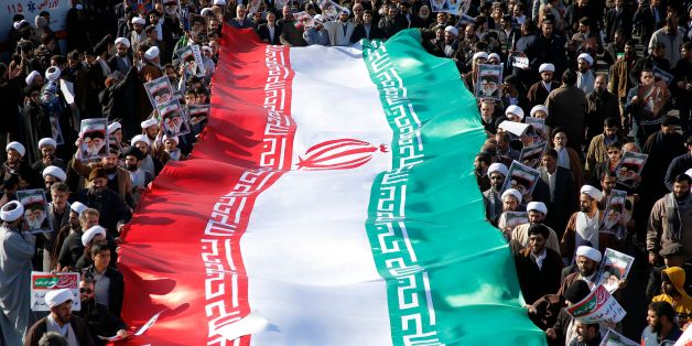 Pro-government demonstrators wave their national flag during a march in Iran's holy city of Qom, some 130 kilometres south of Tehran, on January 3, 2018, as tens of thousands gathered across Iran in a massive show of strength for the Islamic rulers after days of deadly unrest. / AFP PHOTO / Mohammad ALI MARIZAD (Photo credit should read MOHAMMAD ALI MARIZAD/AFP/Getty Images)