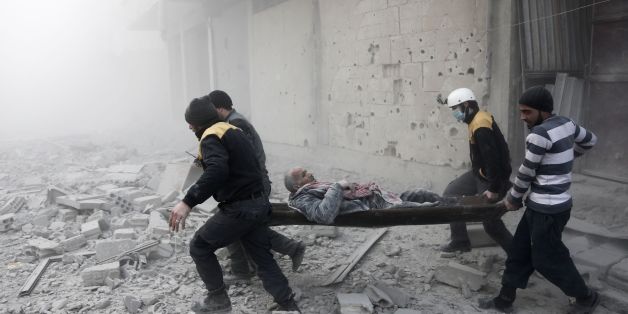 Civilians and members of the civil defence (known as the white helmets) load a wounded man into a vehicle to be taken to a make-shift hospital following an air strike on the rebel-held besieged town of Arbin, in the eastern Ghouta region on the outskirts of the capital Damascus on January 2, 2018. / AFP PHOTO / ABDULMONAM EASSA (Photo credit should read ABDULMONAM EASSA/AFP/Getty Images)