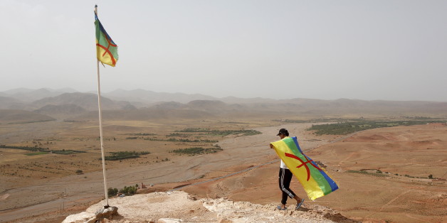 En août 2015, un activiste muni du drapeau amazigh arpente une colline surplombant une mine d'argent, où de nombreux jeunes pauvres ou sans emplois du village d'Imider ont tenu un sit-in permanent et un mouvement social depuis 2011, près de la ville d'Imider, dans le sud est du Maroc. REUTERS/Youssef Boudlal