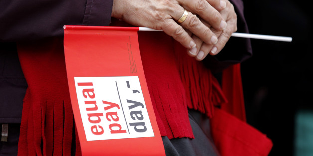A woman holds a flag during a demonstration marking Equal Pay Day in Berlin March 21, 2014. REUTERS/Tobias Schwarz (GERMANY - Tags: POLITICS)