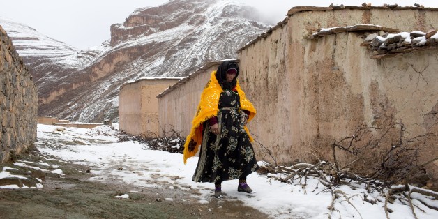 A woman walks through the snow covered village of Tilmi in the High Atlas region of Morocco February 13, 2015. The snowy foothills of the High Atlas mountains in Morocco are home to several Berber villages where the inhabitants make their living by farming, baking bread in traditional ovens, herding cattle, and the making and selling of honey, olive oil and pottery. Extreme weather fluctuations and erosion that causes flooding and landslides have led to a drop in agricultural productivity, the U