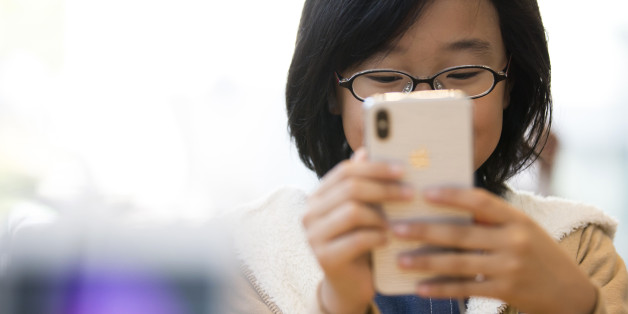 A girl tries an iPhone X at the Apple Omotesando store on November 3, 2017 in Tokyo, Japan. Apple launched the latest iPhone featuring face recognition technology, a large 5.8-inch edge-to-edge high resolution OLED display and better front and back cameras with optical image stabilisation today. (Photo by Tomohiro Ohsumi/Getty Images)