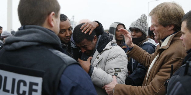Pascal Brice (R), the head of OFPRA, French Office for Refugees and Stateless Persons, comforts an Ethiopian migrant, member of the Oromo community, who cries as he leaves the "Jungle" to be transfered to reception centers during the start of the dismantlement of the camp in Calais, France, October 24, 2016. REUTERS/Pascal Rossignol