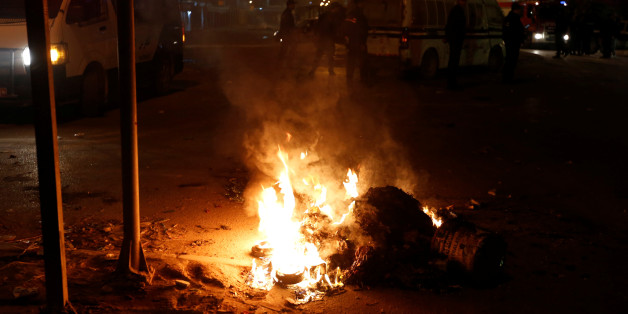 Police vehicles stop in front of burning tires set up by protesters during demonstrations against rising prices and tax increases, in Tunis, Tunisia, January 8, 2018. REUTERS/Zoubeir Souissi