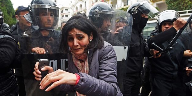 Tunisian police stand guard during a demonstration against the government and price hikes on January 9, 2018 in Tunis.Protests hit several parts of Tunisia where dozens of people were arrested and one man died in unclear circumstances amid anger over rising prices, authorities said. / AFP PHOTO / FETHI BELAID (Photo credit should read FETHI BELAID/AFP/Getty Images)