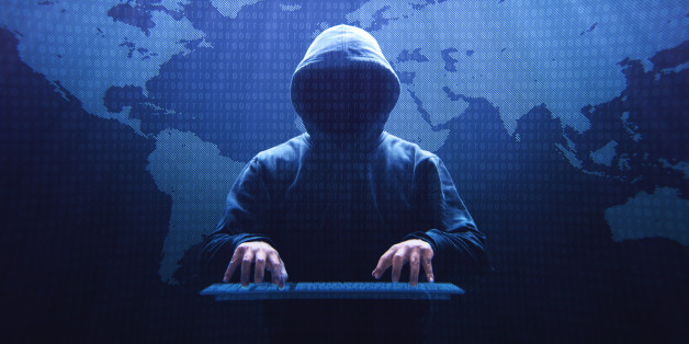 Anonymous computer hacker sitting in front of a virtual screen.