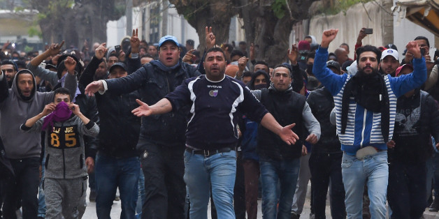 TOPSHOT - Tunisian protesters gesture towards security forces during clashes in the town of Tebourba on January 9, 2018, following the funeral of a man who was killed the previous day in a demonstration over rising costs and government austerity. / AFP PHOTO / Fethi Belaid (Photo credit should read FETHI BELAID/AFP/Getty Images)