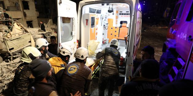 Syrian emergency personnel carry a victim into an ambulance following an explosion at a base for Asian jihadists in a rebel-held area of the northwestern city of Idlib on January 7, 2018. / AFP PHOTO / OMAR HAJ KADOUR (Photo credit should read OMAR HAJ KADOUR/AFP/Getty Images)