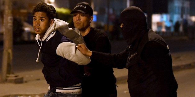 TOPSHOT - Tunisian security forces detain a protester in the Ettadhamen on the outskirts of Tunis late on January 10, 2018, after price hikes ignited protests in the North African country.
More than 200 people have been arrested and dozens of police hurt during clashes in Tunisia, the interior ministry said, as anger over austerity measures spilt over into unrest
/ AFP PHOTO / FETHI BELAID (Photo credit should read FETHI BELAID/AFP/Getty Images)