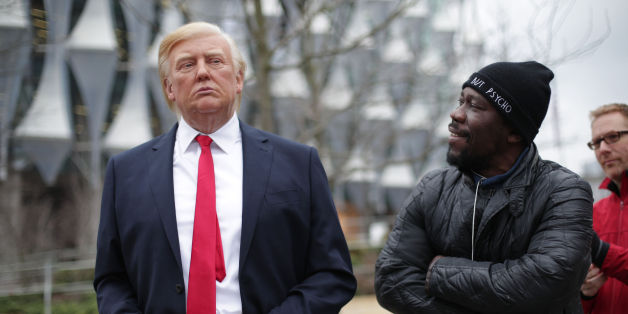 A man stands next to the Madame Tussauds wax figure of US President Donald Trump outside the new US Embassy in Nine Elms, London, after Mr Trump confirmed he will not travel to the UK to open the new building - and hit out at the location of the 1.2 billion dollar (£886 million) project. (Photo by Yui Mok/PA Images via Getty Images)