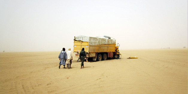 Militiaman from the Ansar Dine Islamic group approach a vehicle that had been involved in an accident in the desert of northeastern Mali, June 15, 2012. The U.N. Security Council on Monday declared its readiness to consider backing West African military intervention in Mali, where rebels and Islamist militants have seized control of much of the country, but said it needed more details on the plan. Picture taken June 15, 2012. REUTERS/Adama Diarra (MALI - Tags: POLITICS CIVIL UNREST CONFLICT RELI