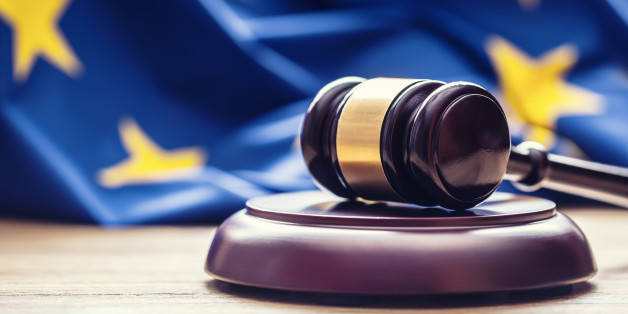 Judges wooden gavel with EU flag in the background. Symbol for jurisdiction.
