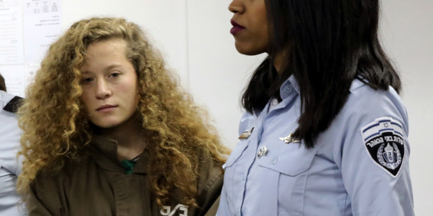 Palestinian teen Ahed Tamimi enters a military courtroom escorted by Israeli Prison Service personnel at Ofer Prison near the West Bank city of Ramallah, December 28, 2017. REUTERS/Ammar Awad