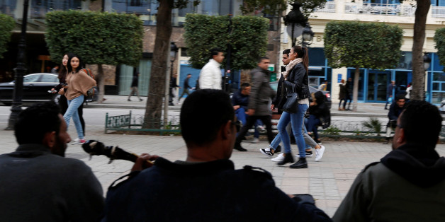 People pass by members of a musical group performing on Habib Bourguiba Avenue in Tunis, Tunisia January 17, 2018. REUTERS/Zoubeir Souissi