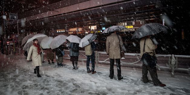 People wait in a queue for taxis at Akihabara station during a snowfall in Tokyo on January 22, 2018.Japan's weather agency issued a heavy snow warning for Tokyo for the first time in four years, urging people to go home early amid fears of public transport chaos. / AFP PHOTO / Behrouz MEHRI (Photo credit should read BEHROUZ MEHRI/AFP/Getty Images)