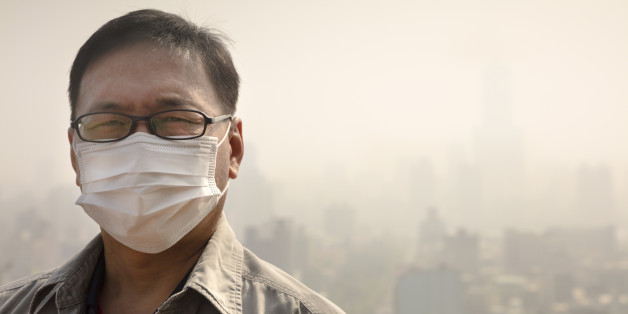 Asian man wearing mouth mask against air pollution