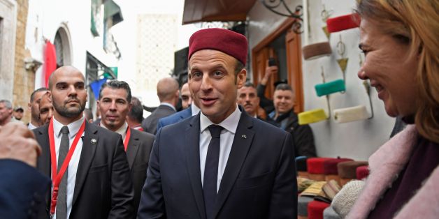 French President Emmanuel Macron (C) tries on a fez as he tours the Medina (old town) of the Tunisian capital Tunis on February 1, 2018, during his first state visit to the North African country. / AFP PHOTO / POOL / Eric FEFERBERG (Photo credit should read ERIC FEFERBERG/AFP/Getty Images)