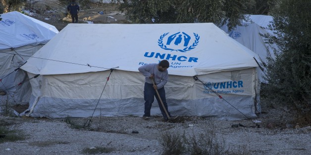LESBOS, GREECE - NOVEMBER 21: A refugee digs with a shover in front of a United Nations High Commissioner for Refugees (UNHCR) Refugee Agency tent at the Moria Refugee Camp in Lesbos, Greece on November 21, 2017. Overpopulated refugee camp is comprised mostly of children and women. (Photo by Ayhan Mehmet/Anadolu Agency/Getty Images)