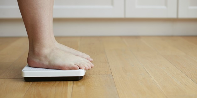Woman standing on weighing scales.