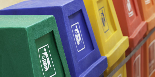 A row of recycling bins in different colors at a recycling station.