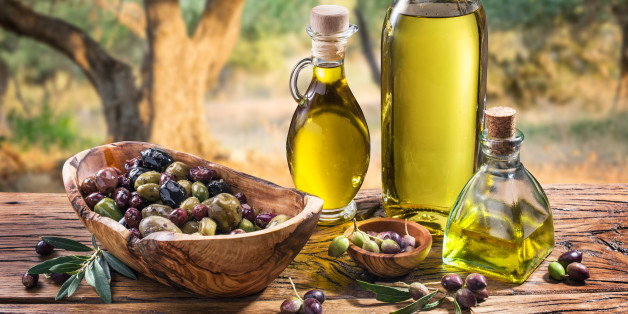 Olives and olive oil in a bottle on the background of the evening olive grove.