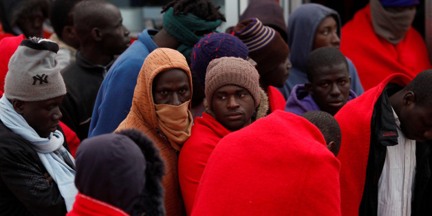 Migrants, part of a group intercepted aboard a dinghy off the coast in the Mediterranean Sea, stand after arriving on a rescue boat at the port of Malaga, Spain January 13, 2018. REUTERS/Jon Nazca