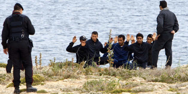 Police stop the people who fled the unrest in Tunisia from leaving the immigration centre during their protest against being sent back to their country, on the southern Italian island of Lampedusa April 11, 2011. Prime Minister Silvio Berlusconi stepped up calls on Saturday for Europe to help deal with the "human tsumani" of refugees and illegal immigrants from North Africa arriving in southern Italian islands in recent weeks. REUTERS/Antonio Parrinello (ITALY - Tags: SOCIETY POLITICS CIVIL