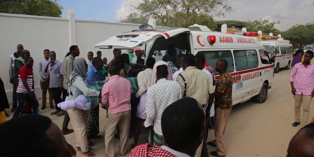 MOGADISHU, SOMALIA - FEBRUARY 24: People carry the body of the victims after two attacks carried out bomb-laden vehicles near Somalian National Intelligence and Security Agency (NISA) building in Mogadishu, Somalia on February 24, 2018. (Photo by Sadak Mohamed/Anadolu Agency/Getty Images)