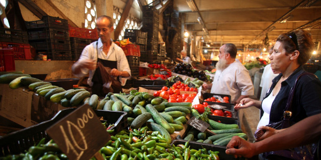 People shop a stand at Ali Mellah market in Algiers on July 27, 2011. Faced with crumbling regimes across the Arab world, Algeria has dramatically boosted its grain imports to contain social unrest ahead of Ramadan, when food prices traditionally shoot up. AFP PHOTO FAROUK BATICHE (Photo credit should read FAROUK BATICHE/AFP/Getty Images)