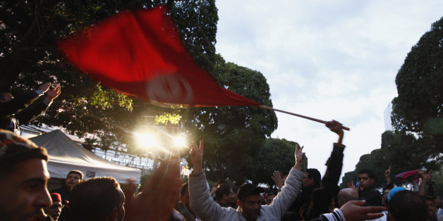 People wave a Tunisian national flag as they dance on Avenue Habib Bourguiba celebrating the second anniversary of the Tunisian revolution in Tunis January 12, 2013. REUTERS/Anis Mili (TUNISIA - - Tags: POLITICS CIVIL UNREST ANNIVERSARY)