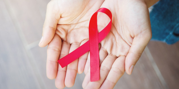 Female hands holding red ribbon HIV, AIDS awareness ribbon, healthcare and medicine concept. retro effect.