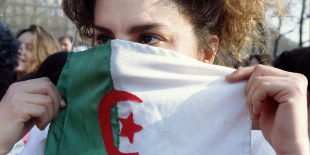 An Algerian girl hides her face in behind an Algerian flag during a demonstration campaigning for women rights in Algeria in Paris March 9. Hundreds of people demonstrated in central Paris the day after international women's day.FRANCE ALGERIA