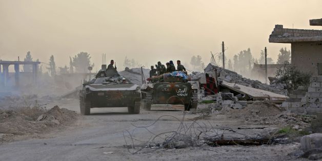 Syrian government forces drive military vehicles in al-Shifoniya as they advance in the rebel-held Eastern Ghouta area on March 4, 2018.Syria's regime seized control of over a quarter of rebel-held Eastern Ghouta on the edge of Damascus after two weeks of devastating bombardment, sending hundreds of civilians into flight, a monitor said Sunday. / AFP PHOTO / STRINGER (Photo credit should read STRINGER/AFP/Getty Images)