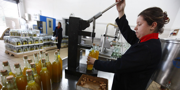 A worker corks bottles of olive oil at the Ifri olive oil factory in the eastern village of Ighzar, near Bejaia, about 250 km (155 miles) from Algiers February 6, 2010. Farmers said the dip in this year's olive oil production was due to unusual weather patterns during the flowering season that had reduced the oil content in the olives. It was also attributed to some olive growers not respecting cultural techniques in the cultivation of olive oil, which led to damage in the new growth during the harvest season. Picture taken February 6, 2010. REUTERS/Zohra Bensemra (ALGERIA - Tags: AGRICULTURE FOOD SOCIETY)