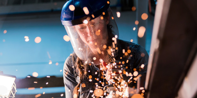 Female welder working in her workshop using an angle grinder. Los Angeles, America. October 2016