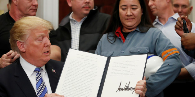 U.S. President Donald Trump signs a presidential proclamation placing tariffs on aluminum imports and steel imports while surrounded by workers from the steel and aluminum industries at the White House in Washington, U.S. March 8, 2018. REUTERS/Leah Millis