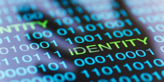 Binary data with the word IDENTITY appears in the shadow of a hand. Concept for digital crime. Blue toned image.