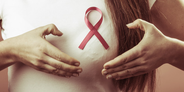 Awareness of breast cancer. Close up of female hands make heart on pink ribbon symbol sign. Help and charity.