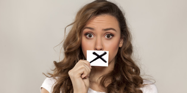 shocked young girl with X sign drawn on paper over her mouth