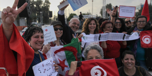 Women wave flags of Tunisia and Algeria, while raising placards and making victory signs, during a march held in Tunis, Tunisia to call for equal inheritance rights and gender equality, on March 10, 2018. (Photo by Chedly Ben Ibrahim/NurPhoto via Getty Images)