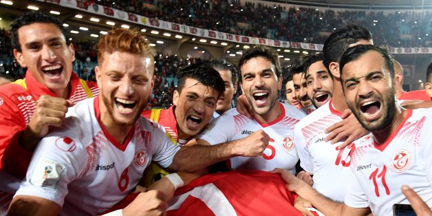 Players of the Tunisian national football team celebrate with their national flag after qualifying for the 2018 World Cup finals after drawing their qualifiers match against Libya at the Rades Olympic Stadium in the capital Tunis on November 11, 2017. / AFP PHOTO / FETHI BELAID (Photo credit should read FETHI BELAID/AFP/Getty Images)